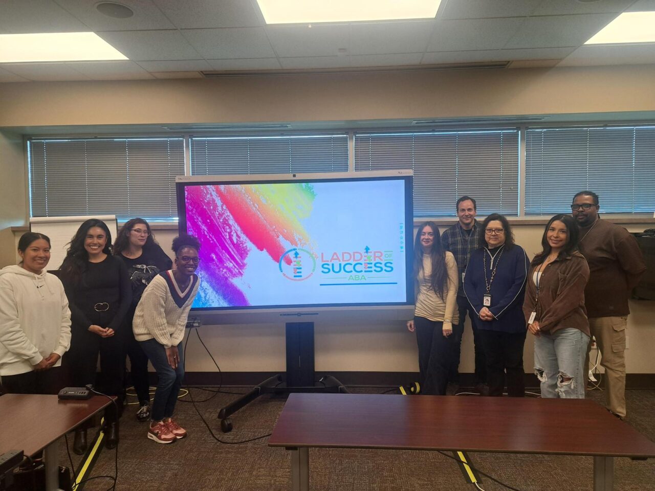 A group gathered beside a presentation screen.