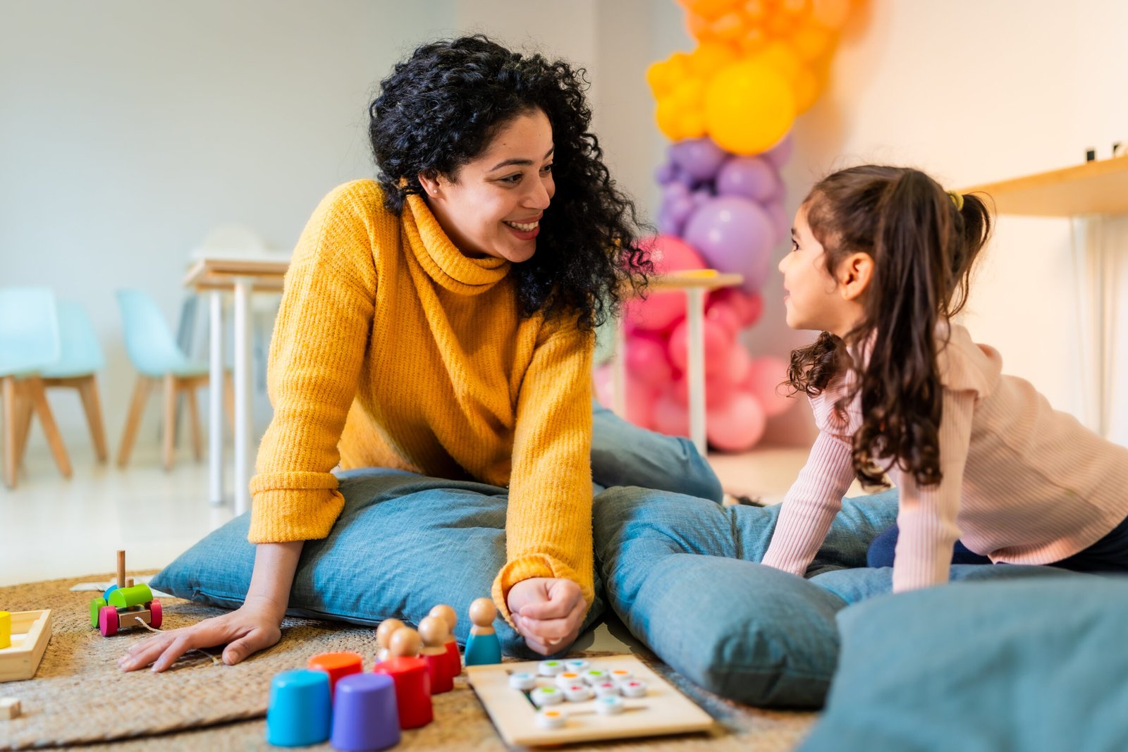 A woman and girl playing with learning toys.